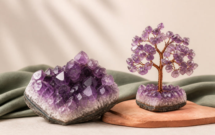 A raw amethyst cluster beside an amethyst chip gemstone tree