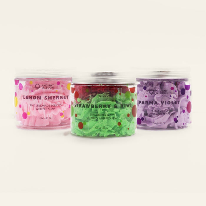 Three tubs of whipped soap side by side — pink lemonade, strawberry and kiwi, and parma violet — each with a silver screw lid